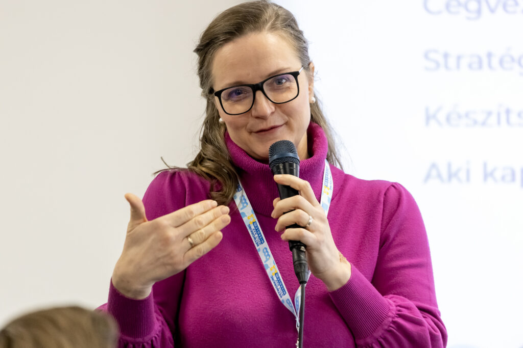 Neisz Laura mikrofonnal beszél egy csoportnak